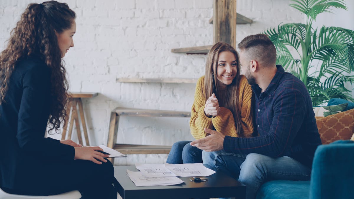 A couple meeting with an advisor in a living room.